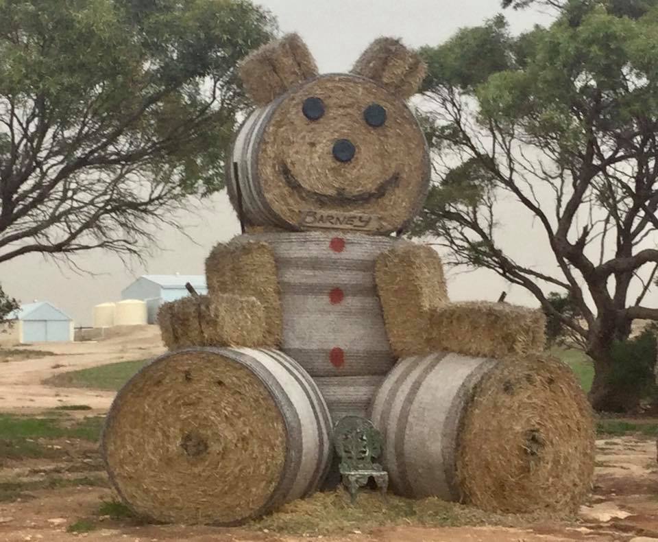 The big teddy bear is made out of hay bails and represents a teddy bear sitting down